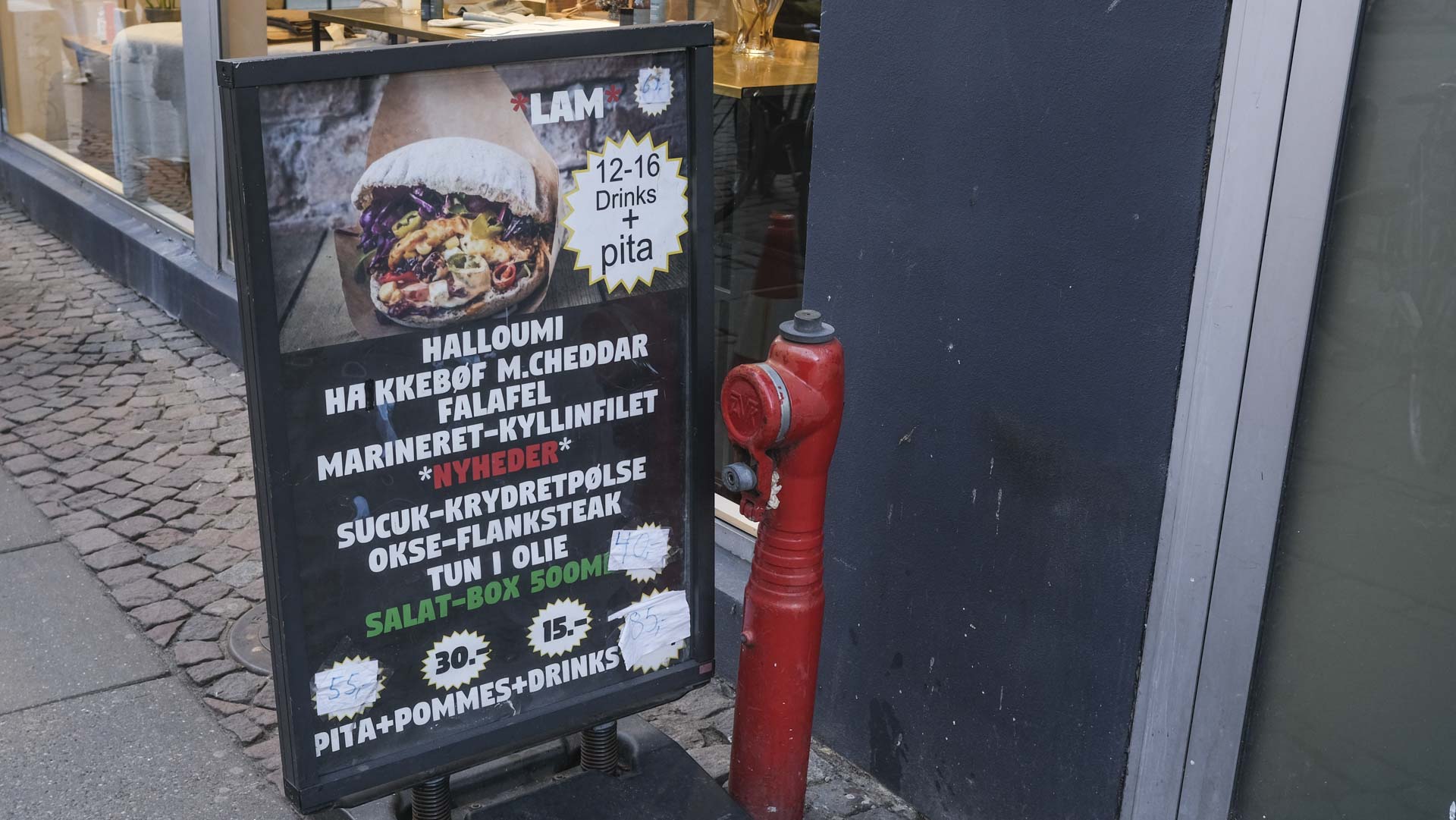 Skiltet med priserne på gaden hos The Original Pita