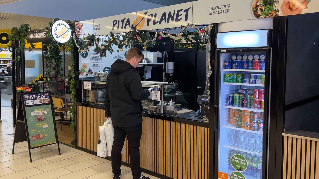 Her står en kunde og bestiller mad hos Pita Planet Pure i Storcenter Nord