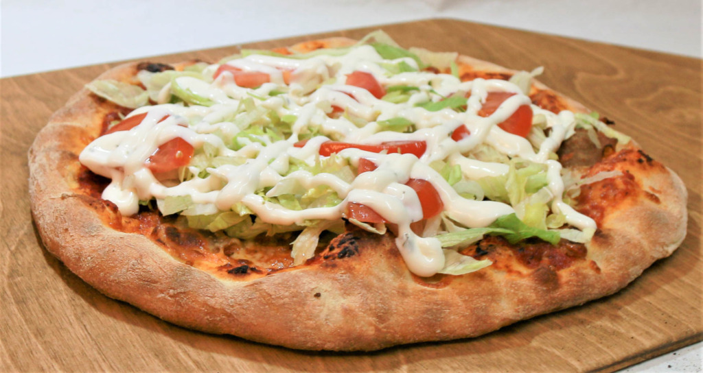 En pizza med salat fra Rundhøj Pizza & Grill