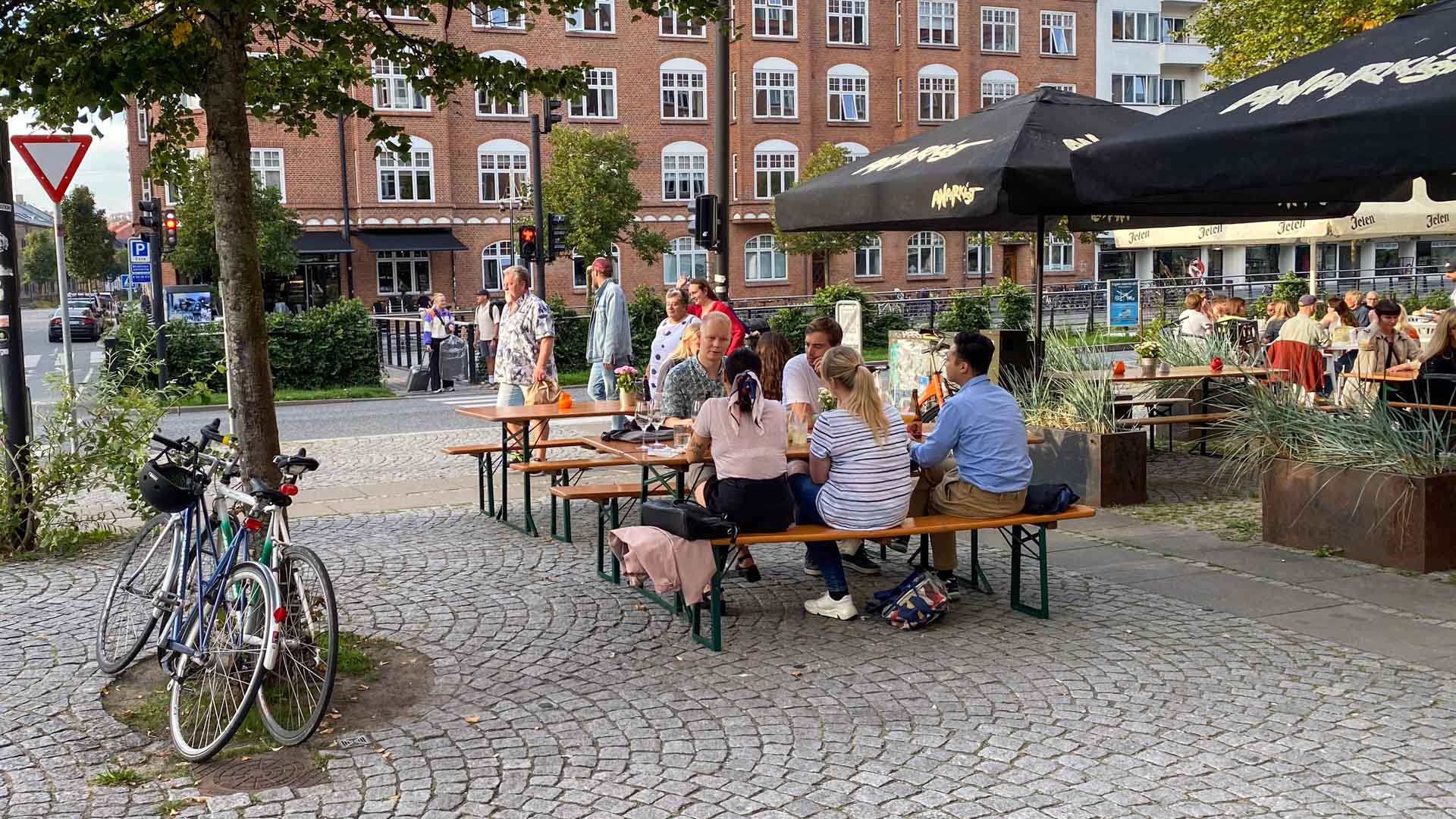 Man sidder ved træborde og på træbænke udenfor hos Stechers