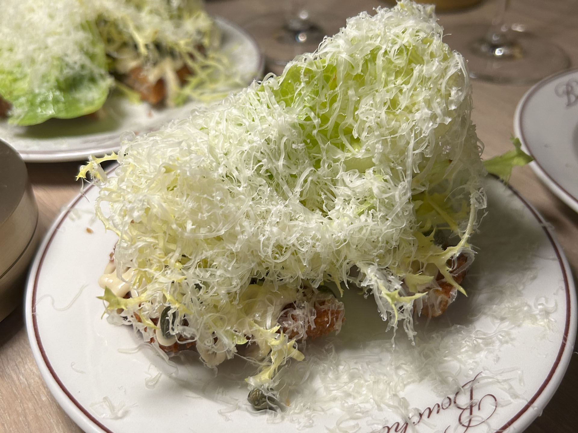 Schnitzel med vitello tonnatosauce, hjertesalat og parmesan, delt i to