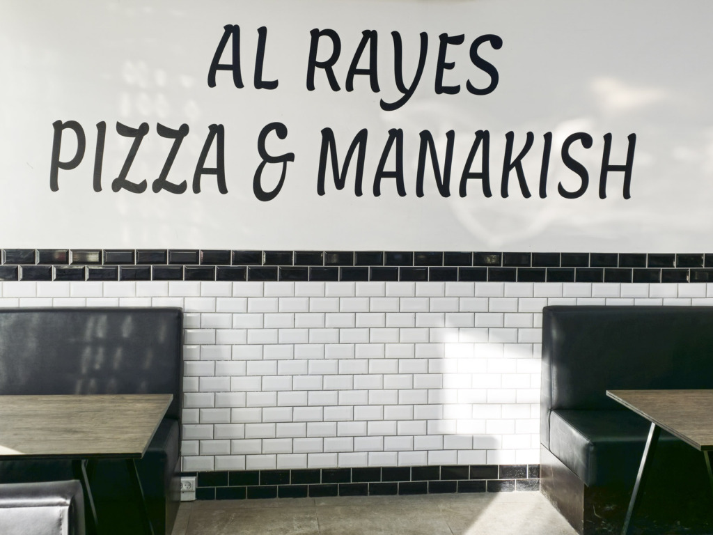En skilt p&aring; v&aelig;ggen hos Al Rayes &ndash; Pizza & Manakish i Brabrand
