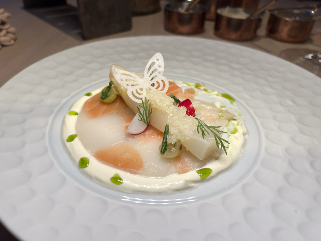 en carpaccio af saltet laks og kammusling i univers af kefirfløde og dild. En frisk havgus af smage i sig selv og yderligere eleveret med en ærte-smagende hvid asparges