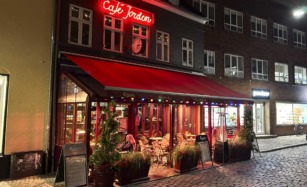 Café Jorden i Aarhus C set udefra Pustervig af en se sen aftentime.