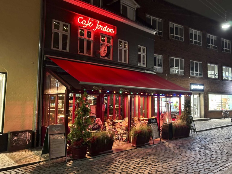 Café Jorden i Aarhus C set udefra Pustervig af en se sen aftentime.