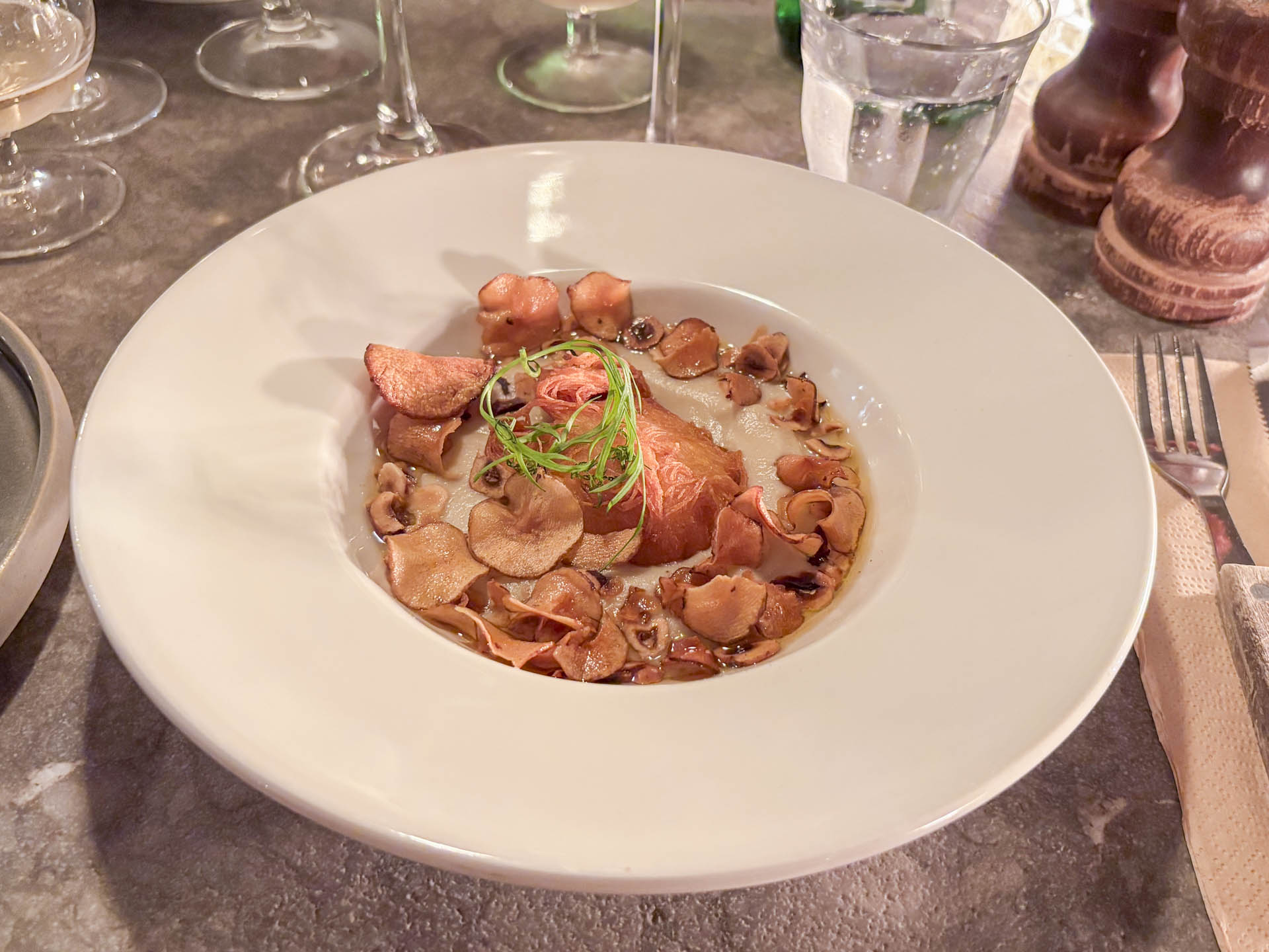 jordskokkebisque med kataifi-friteret kammusling, jordskokkechips, hasselnød og brunet smør. 