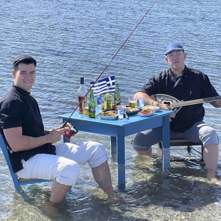 Her sidder far og s&oslash;n i vandkanten og spiser. Sevag og Garo Aharounian ses p&aring; billedet.