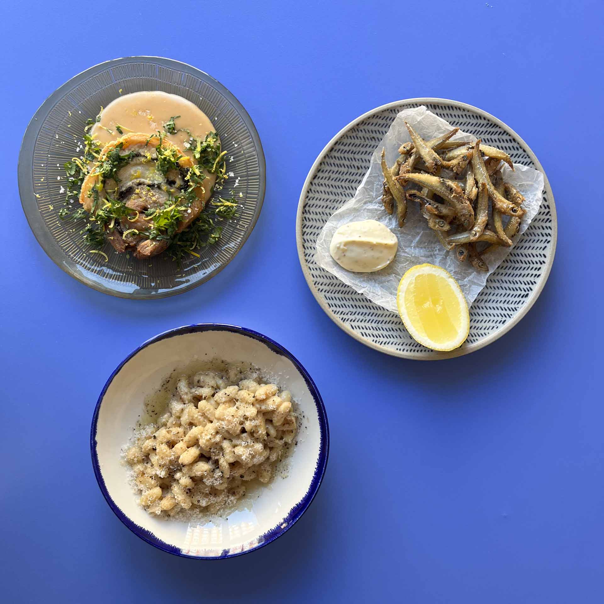 Tre små retter på blåt bord set oppefra hos Elle Belle ved åen i Aarhus