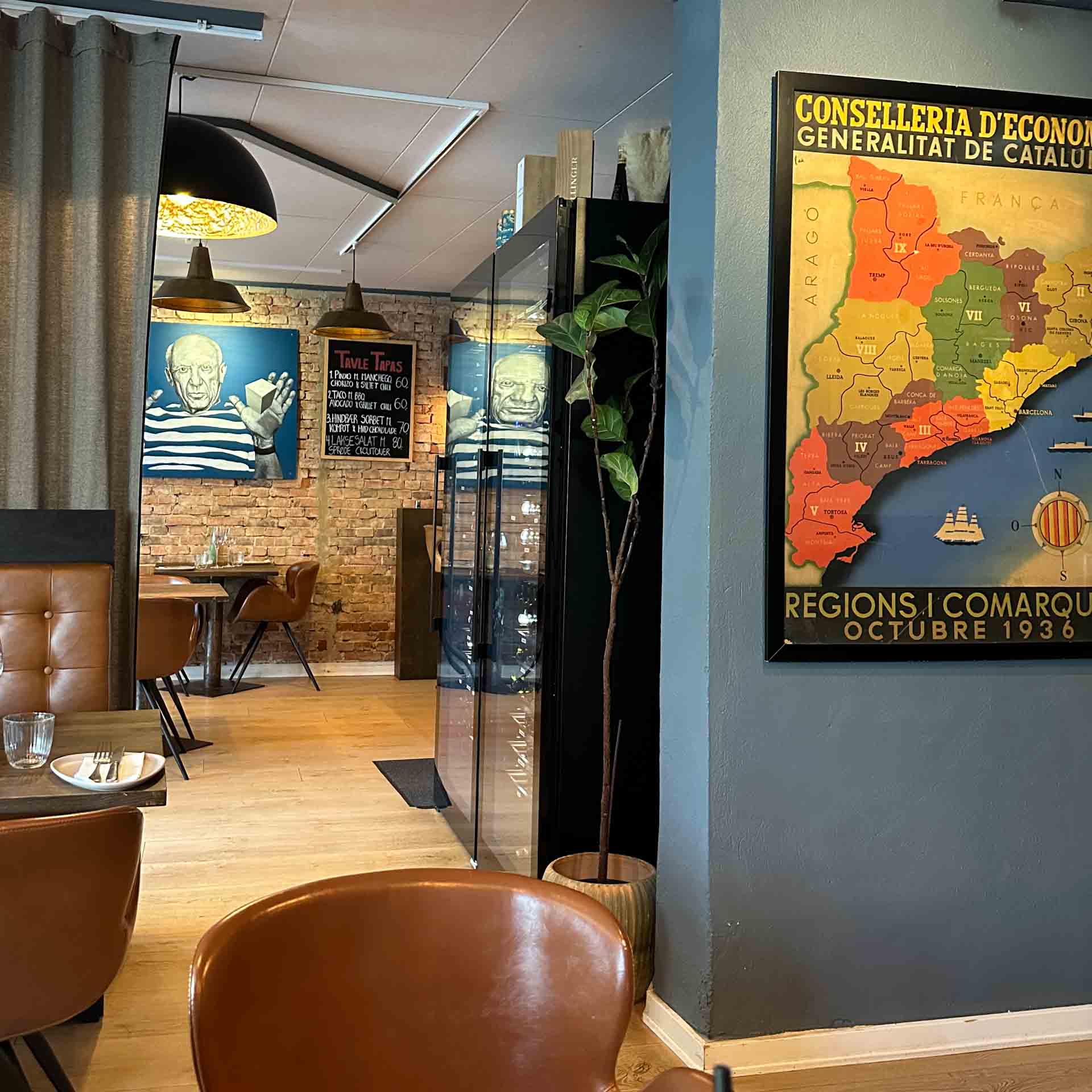 Lokalet med blå vægge og landkort hos Restaurant Socios i Aarhus C