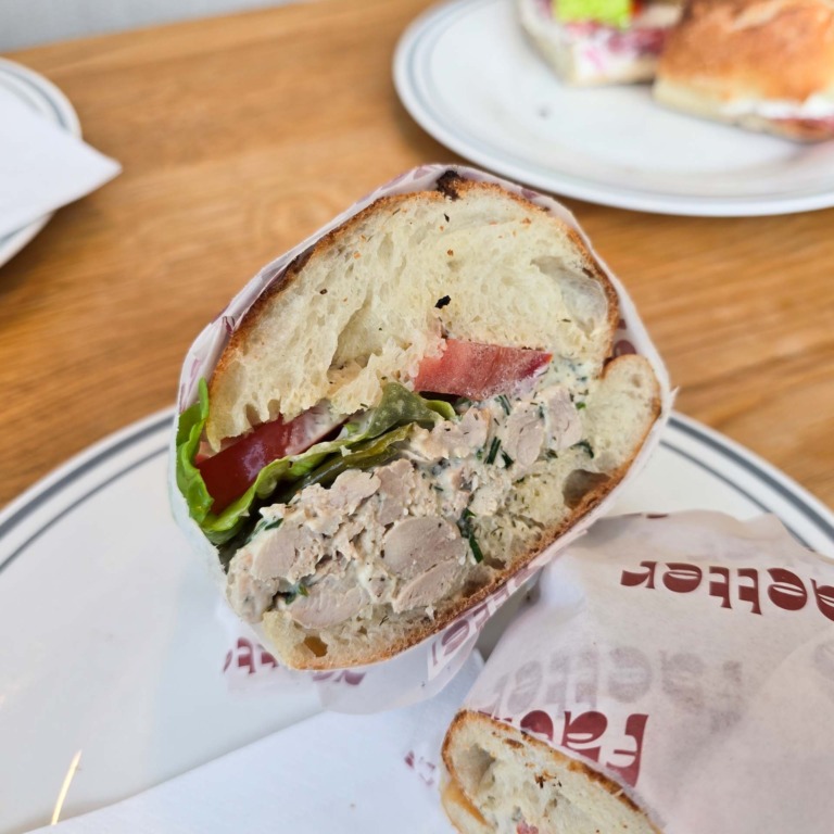 Sandwich med kyllingesalat, tomat og salat i indpakningspapir hos F&aelig;tter p&aring; Godsbanen.