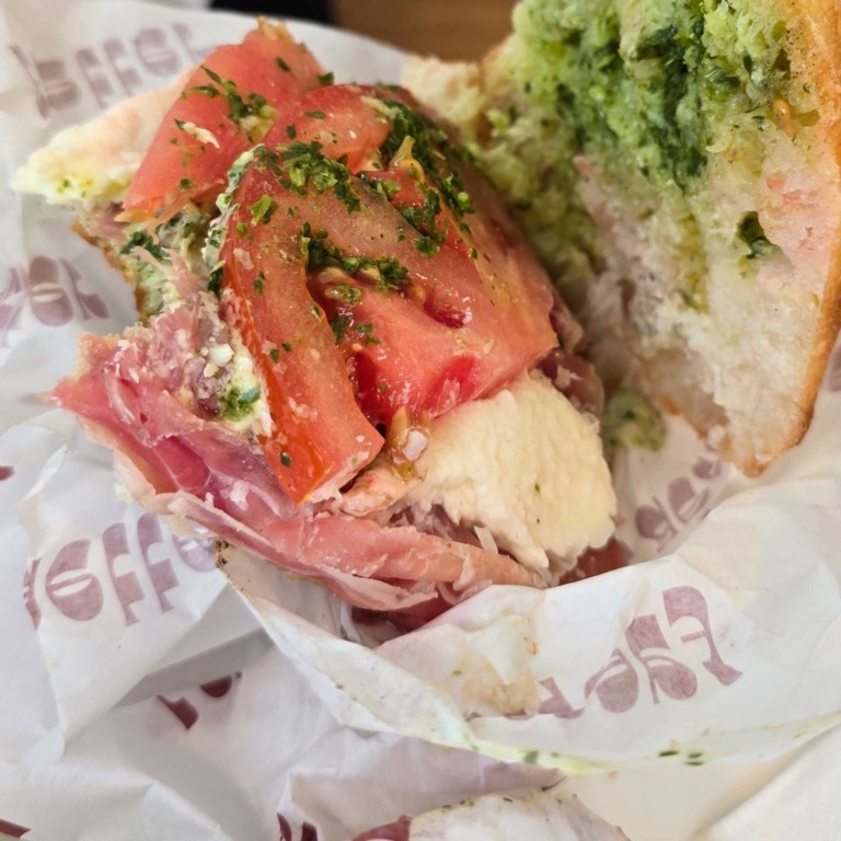 Sandwich med parmaskinke, mozzarella, tomat og pesto i indpakningspapir hos F&aelig;tter p&aring; Godsbanen.