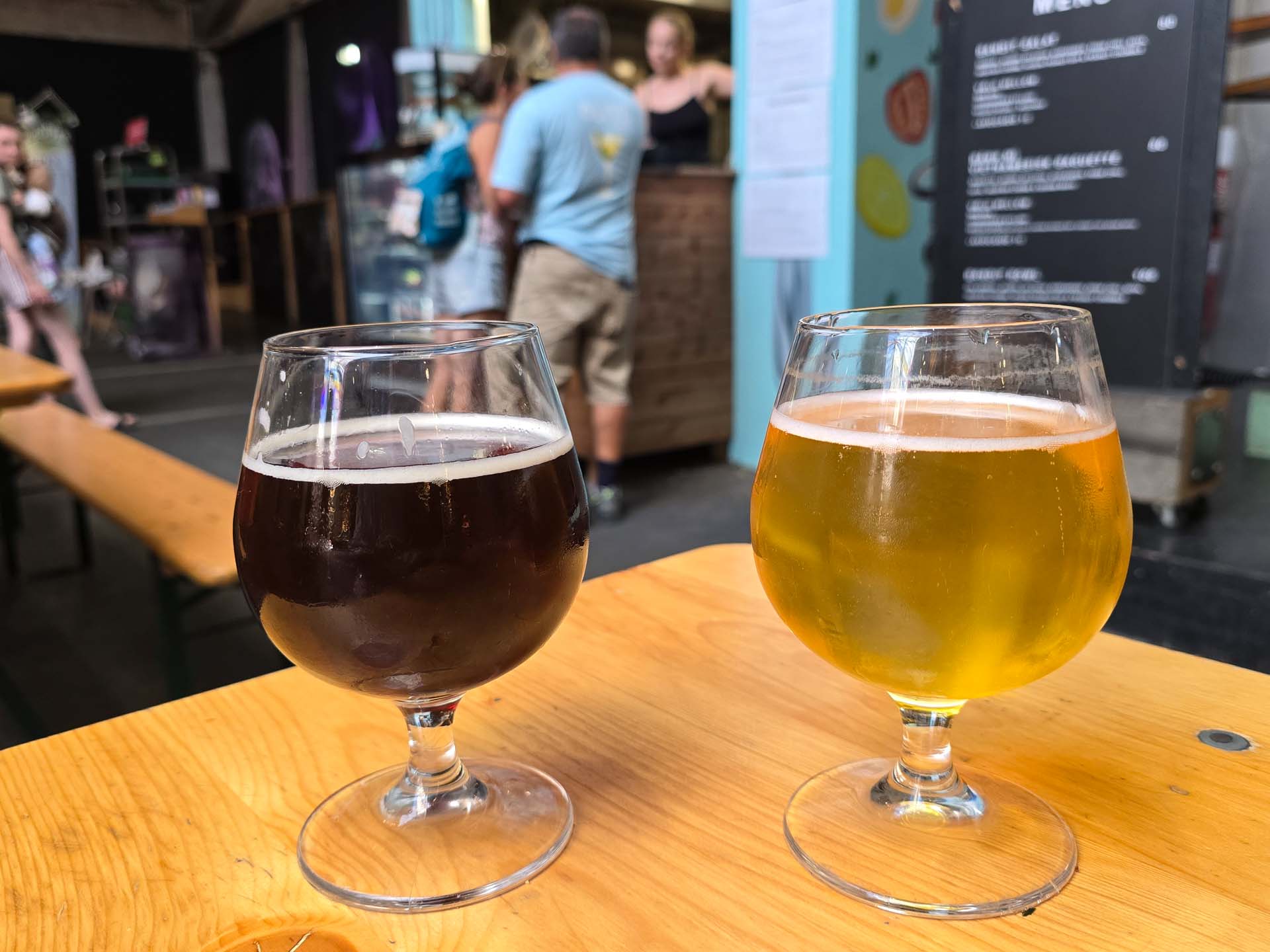 To øl-glas, en mørk og en lys, på træbord foran Livretten i Aarhus Street Food.