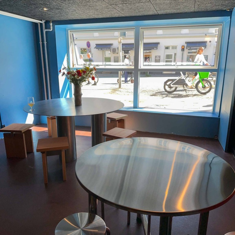 Runde borde ved vinduet og bl&aring; v&aelig;g hos Ratata Bar i N&oslash;rre All&eacute; i Aarhus