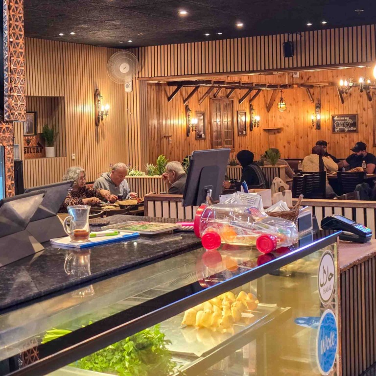 Restaurantlokale med lamper og tr&aelig;paneler hos Al Sultan i Brabrand
