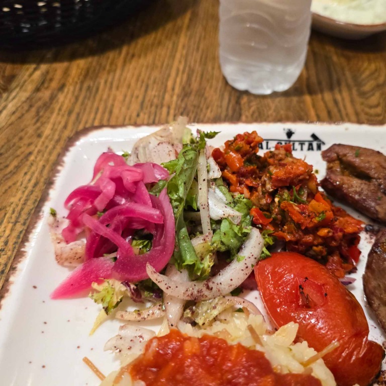Tallerken med salat, syltede l&oslash;g og grillet tomat hos Al Sultan i Brabrand