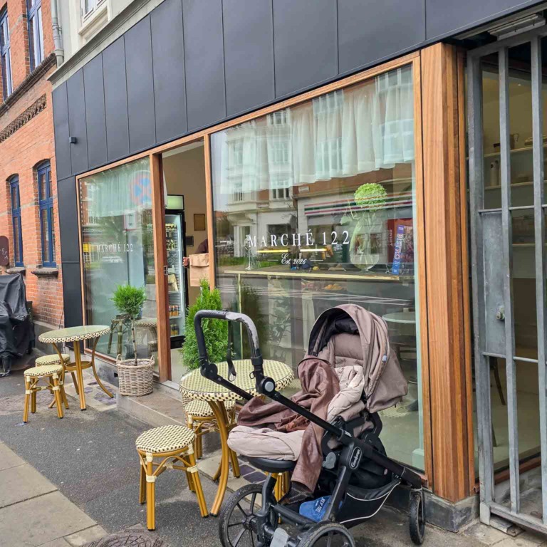 Facade med sm&aring; borde og taburetter p&aring; fortovet hos March&eacute; 122 i Aarhus C