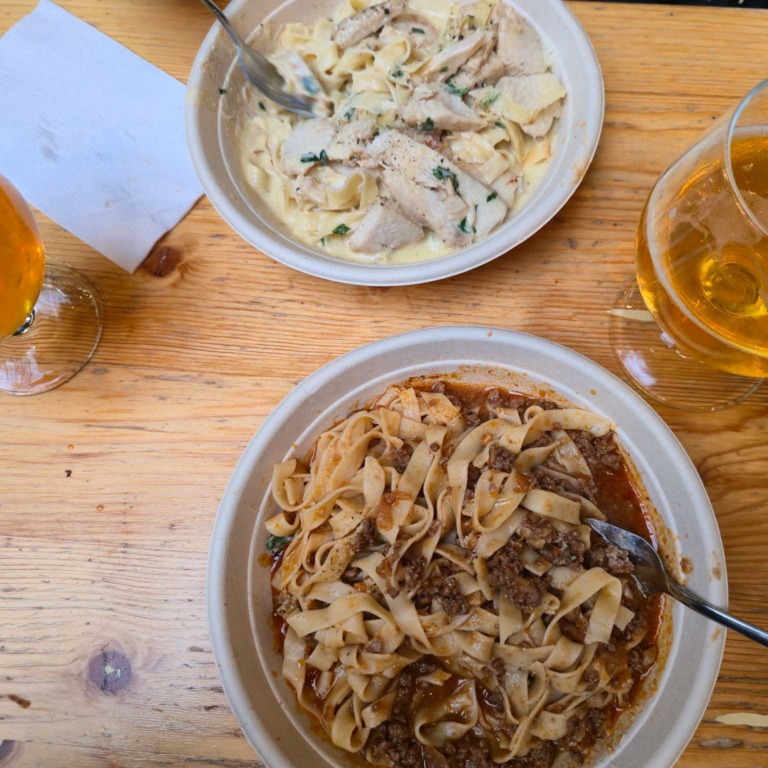 To tallerkener med frisk pasta og et glas &oslash;l hos Pasta Fresca i Aarhus Street Food
