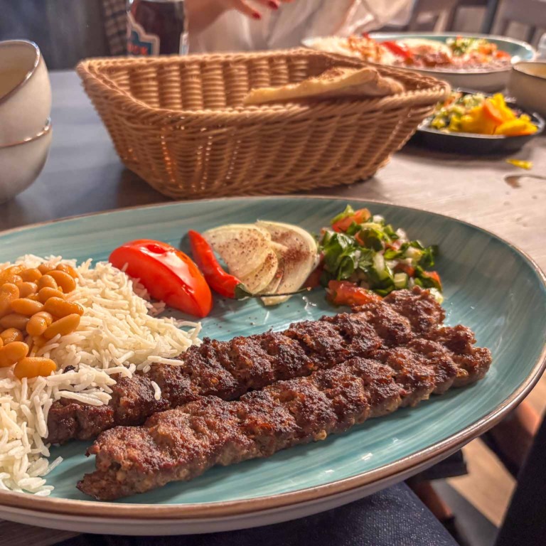 Kebab med ris, b&oslash;nner, salat og grillede peberfrugter