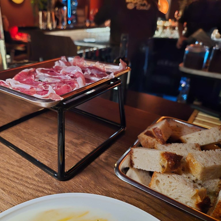 Skinke, br&oslash;d og tallerken p&aring; bordet hos Boca R&eacute;al
