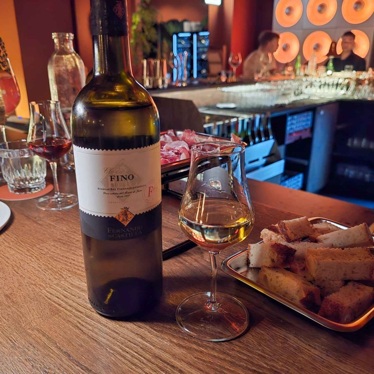 Vinflaske og glas p&aring; bordet ved baren hos Boca R&eacute;al