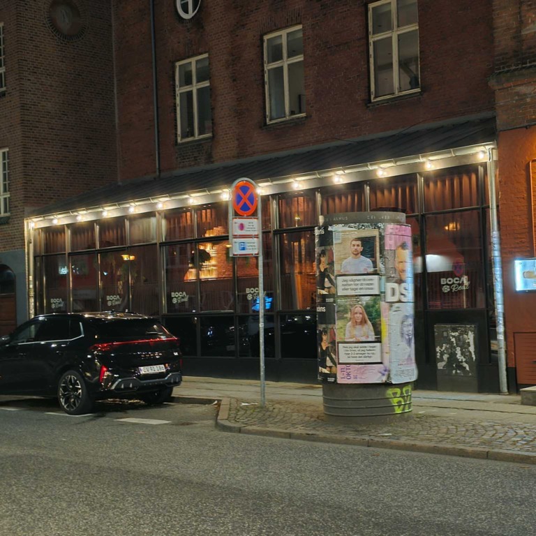 Boca R&eacute;al set fra gaden i Klosterport med lys under facaden