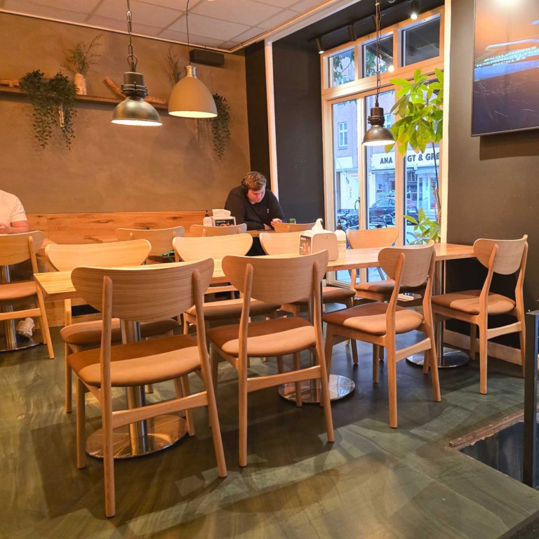 Lokalet med tr&aelig;stole og h&aelig;ngelamper hos Burger Boom p&aring; Tr&oslash;jborg