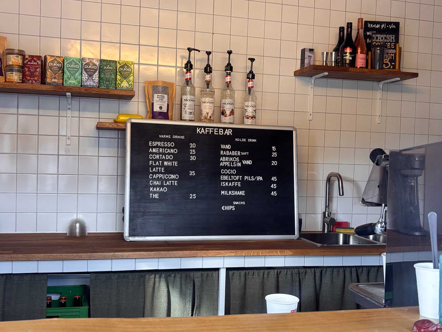 Tavle med kaffekort og sirupper i kaffebaren hos Institut for X