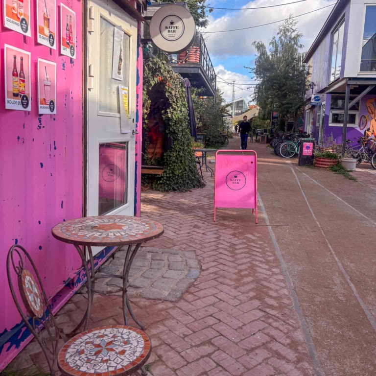 Lille bord og pink skilt ved kaffebaren hos Institut for X