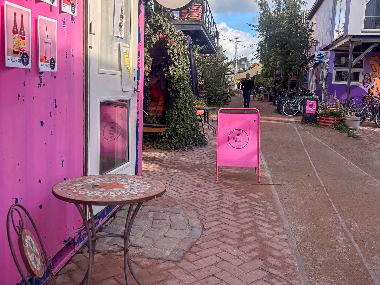 Lille bord og pink skilt ved kaffebaren hos Institut for X