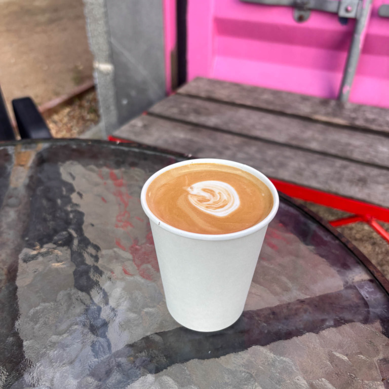 Kaffe med latte art i papkrus