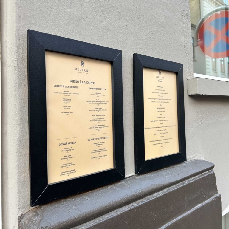 Menukort i rammer ved indgangen til Restaurant Ukurant i Mejlgade i Aarhus