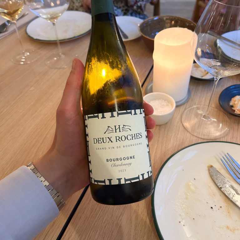 En flaske hvidvin vises frem ved bordet hos Restaurant Ukurant i Mejlgade i Aarhus