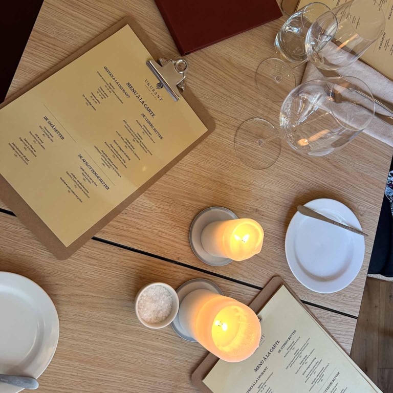 Menukort og stearinlys p&aring; bordet hos Restaurant Ukurant i Mejlgade i Aarhus