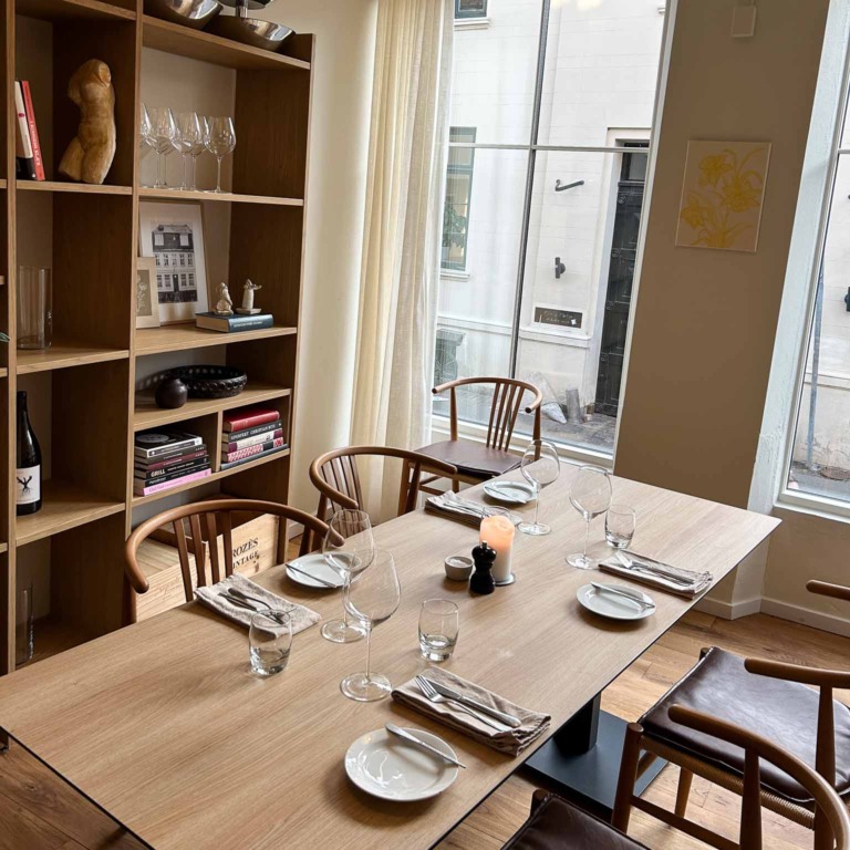 D&aelig;kket bord ved reolen og vinduet hos Restaurant Ukurant i Mejlgade i Aarhus
