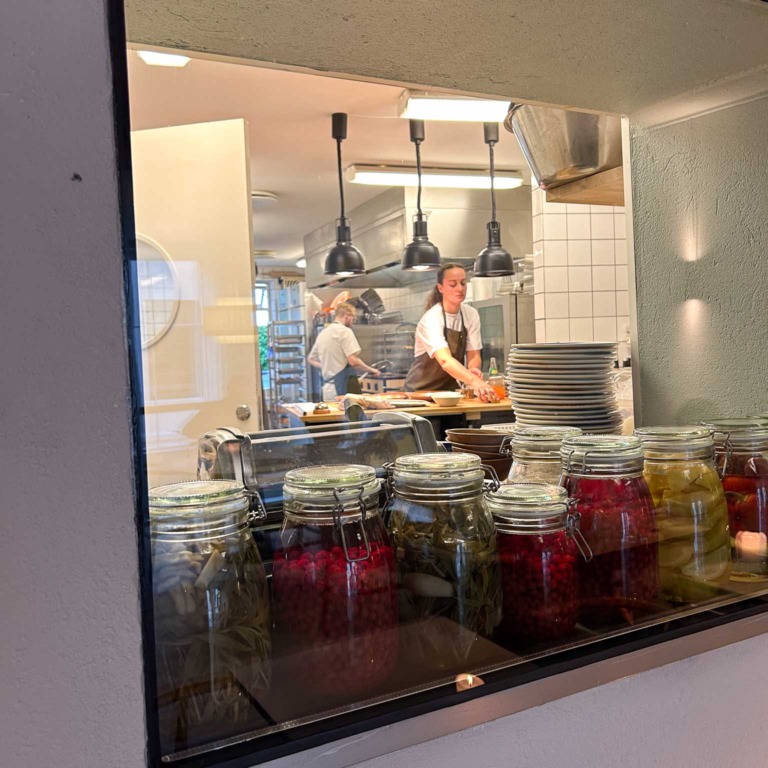 Kig ind til k&oslash;kkenet og syltede gr&oslash;ntsager i glas hos Restaurant Ukurant i Mejlgade i Aarhus