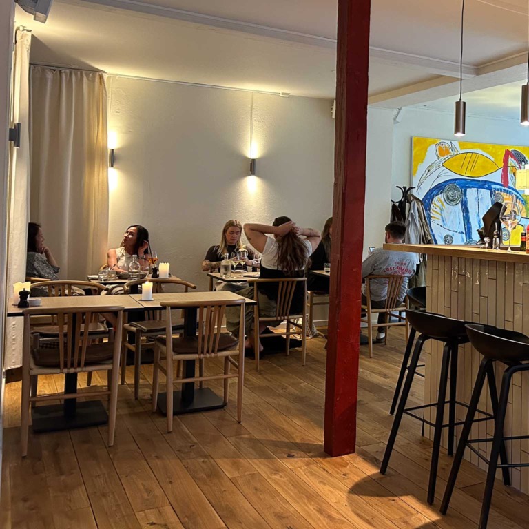 G&aelig;ster ved bordene og baren hos Restaurant Ukurant i Mejlgade i Aarhus